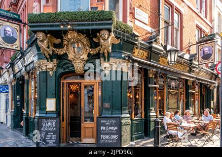 Menschen, die vor dem Salisbury Pub in St. Martin's Lane, London, Großbritannien, sitzen. Stockfoto