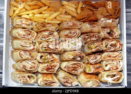 Syrisches Rezept Küche Hintergrund, eine Box voller Stücke von Huhn Shawerma oder Shawarma Tortilla Wrap mit Zwiebeln, Tomaten, Salat und Knoblauchsauce in S Stockfoto