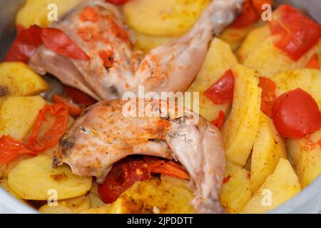 Hähnchenschenkel und Oberschenkel mit Kartoffelscheiben, Tomaten und Zwiebeln mit im Ofen gebackenen, im Ofen gebackenen Gewürzen, selektiver Fokus auf ägyptische Speisen c Stockfoto