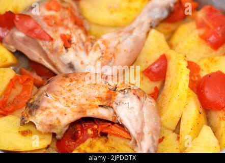 Hähnchenschenkel und Oberschenkel mit Kartoffelscheiben, Tomaten und Zwiebeln mit im Ofen gebackenen, im Ofen gebackenen Gewürzen, selektiver Fokus auf ägyptische Speisen c Stockfoto