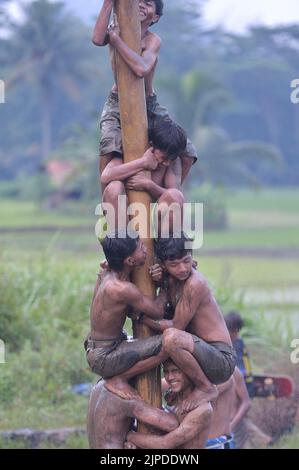 Bogor, Indonesien. 17. August 2022. Kinder nehmen am 17. August 2022 an einem rutschigen Polkletterspiel Teil, um den Unabhängigkeitstag 77. im Dorf Rabak, Bogor, Bezirk der Provinz West Java, Indonesien, zu feiern. Quelle: Veri Sanovri/Xinhua/Alamy Live News Stockfoto