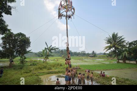 Bogor, Indonesien. 17. August 2022. Kinder nehmen am 17. August 2022 an einem rutschigen Polkletterspiel Teil, um den Unabhängigkeitstag 77. im Dorf Rabak, Bogor, Bezirk der Provinz West Java, Indonesien, zu feiern. Quelle: Veri Sanovri/Xinhua/Alamy Live News Stockfoto