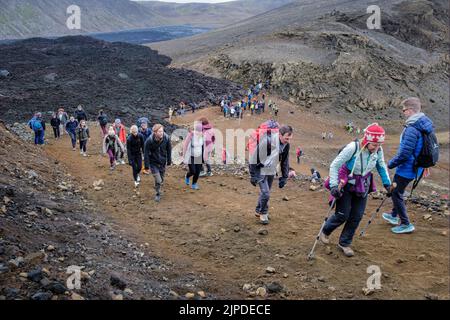 Wanderer machen sich auf den Weg, um den Ausbruch des isländischen Meradalir-Vulkans im August 2022 zu sehen Stockfoto