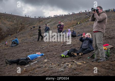 Touristen, die den Ausbruch des Meradalir Vulkans auf der Halbinsel Reykjanes, Island, im August 2022 fotografieren Stockfoto