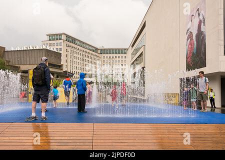 London, England, Großbritannien. 16. August 2022. Die Dürre und Hitzewelle in Großbritannien ist endlich vorbei - Kinder genießen Jeppe Hein's appearingt Rooms Wasserfontäne und einige seltene Regen auf Londons Southbank. © Benjamin John Stockfoto