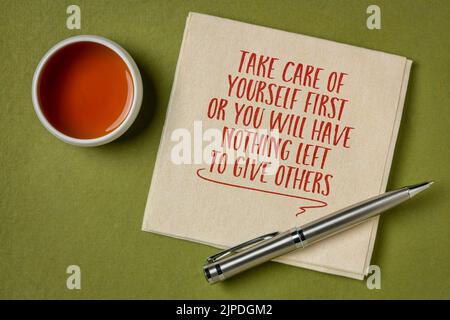 Kümmern Sie sich zuerst um sich selbst, sonst haben Sie nichts mehr, um anderen zu geben, Selbstpflege-Konzept, Handschrift auf Serviette mit einer Tasse Tee Stockfoto