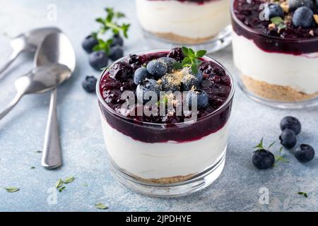 Heidelbeer-Käsekuchen in einem Glas mit graham-Cracker-Basis Stockfoto