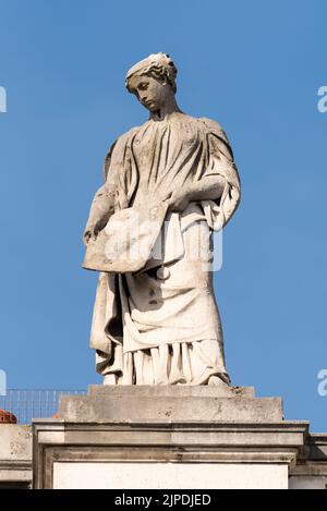 Britannia und ihre Begleiter Skulpturen auf dem Regierungsgebäude des Auswärtigen Amtes und des Commonwealth Office, London, Großbritannien. Gesetzgebung, Frau mit Papierfigur Stockfoto