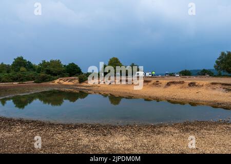 Frogham, Fordingbridge, New Forest, Hampshire, Großbritannien, 17.. August 2022, Wetter: Gewitter verdunkelt den Himmel am Nachmittag am Abbots Well, wo der Teich in der Dürre fast ausgetrocknet ist. Kredit: Paul Biggins/Alamy Live Nachrichten Stockfoto