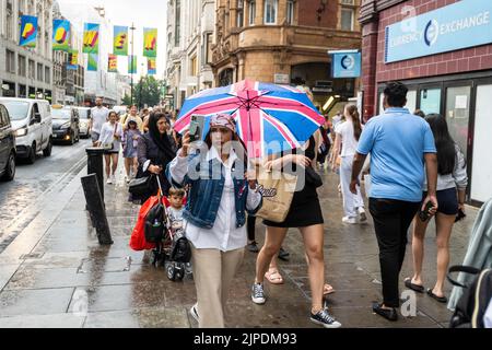 London, Großbritannien. 17. August 2022. Wetter in Großbritannien – die Menschen sind in der Oxford Street von einem Regenschauer erfasst, da die Regenfälle das trockene Wetter wochenlang beenden. Der trockenste Bann in England seit 46 Jahren führte dazu, dass viele Teile des Landes laut der Umweltbehörde offiziell ‘in Dürre’ eingestuft wurden. Kredit: Stephen Chung / Alamy Live Nachrichten Stockfoto