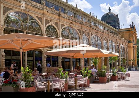 Marienbad, Tschechische Republik, 30. Juni 2022: Außenansicht der alten Kolonnaden im Kurort, Café mit Touristen, die das Frühstück genießen Stockfoto