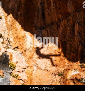 Schatten eines Kletterers, der auf den Berg klettert Stockfoto