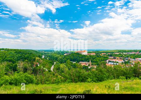Panoramablick vom Hügel in der Nähe von Dolni Kounice Stadt. Blick auf die Burg Dolni Kounice und die antike Ruine des Klosters Rosa Coeli. Palava Hügel im Hintergrund Stockfoto