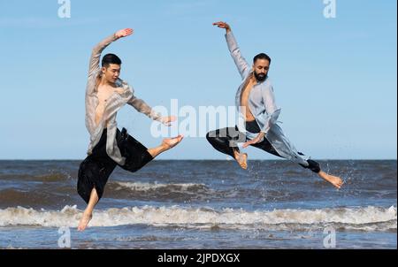 Edinburgh, Schottland, Großbritannien. 17.. August 2022. Die Tänzer Aakash Odedra und Hu Shenyuan von der Aakash Odedra Dance Company führen vor der Eröffnung ihrer Produktion Samsara am 18.. August im Lyceum Theatre in Edinburgh im Rahmen des Edinburgh International Festival 2022 Tanzbewegungen am Portobello Beach durch. Iain Masterton/Alamy Live News Stockfoto