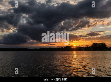 Sonnenuntergang am Bodensee mit kräftigem Wolkenbruch und Sonnenstrahlen Stockfoto