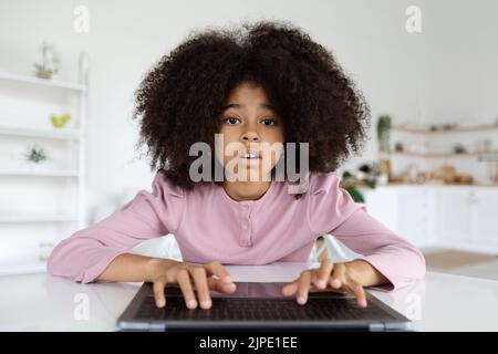 Nahaufnahme von niedlichen schwarzen präteen Mädchen Eingabe auf Laptop-Tastatur Stockfoto
