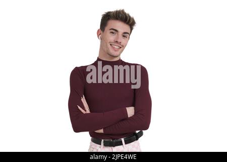 Junger kaukasischer Mann lächelt mit gekreuzten Armen und Ohrhörern, isoliert. Stockfoto