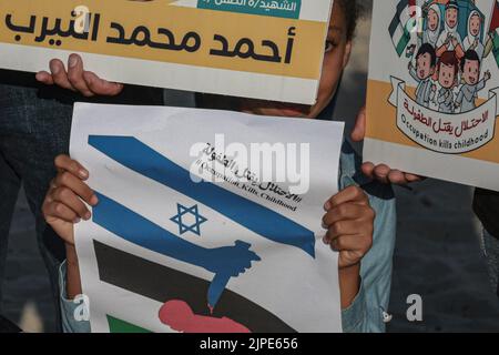 Gaza-Stadt, Palästinensische Gebiete. 17. August 2022. Palästinensische Kinder halten Plakate während einer Gedenkveranstaltung an der Küste von Gaza City. Kredit: Mohammed Talatene/dpa/Alamy Live Nachrichten Stockfoto