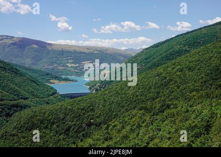 Panorama des Sees Fiastra auf den Sibillini-Bergen in den Marken. Der See liegt mitten in einem grünen Wald. Italien Stockfoto