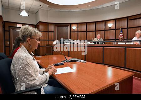 Emporia, Kansas, USA. 17. August 2022. Tammy Vopat (White Top) und Amy Jackson, die stellvertretende Bezirksbeamtin von Lyon, berichten am 17. August 2022 an den Verwaltungsrat der Kommissionsmitglieder von Lyon County in Emporia, Kansas, über die Ergebnisse der Stimmabgabe, die von der Verfassungsänderung berichtet wurde. Die Neuauszählung wurde gezwungen, nachdem zwei Privatbürger angeboten hatten, $120.000 Gebühren für die Neuauszählung zu zahlen.Kredit: Mark Reinstein/Media Punch/Alamy Live News Stockfoto