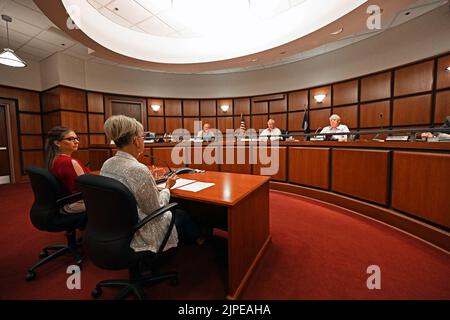 Emporia, Kansas, USA. 17. August 2022. Tammy Vopat (White Top) und Amy Jackson, die stellvertretende Bezirksbeamtin von Lyon, berichten am 17. August 2022 an den Verwaltungsrat der Kommissionsmitglieder von Lyon County in Emporia, Kansas, über die Ergebnisse der Stimmabgabe, die von der Verfassungsänderung berichtet wurde. Die Neuauszählung wurde gezwungen, nachdem zwei Privatbürger angeboten hatten, $120.000 Gebühren für die Neuauszählung zu zahlen.Kredit: Mark Reinstein/Media Punch/Alamy Live News Stockfoto