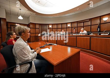 Emporia, Kansas, USA. 17. August 2022. Tammy Vopat (White Top) und Amy Jackson, die stellvertretende Bezirksbeamtin von Lyon, berichten am 17. August 2022 an den Verwaltungsrat der Kommissionsmitglieder von Lyon County in Emporia, Kansas, über die Ergebnisse der Stimmabgabe, die von der Verfassungsänderung berichtet wurde. Die Neuauszählung wurde gezwungen, nachdem zwei Privatbürger angeboten hatten, $120.000 Gebühren für die Neuauszählung zu zahlen.Kredit: Mark Reinstein/Media Punch/Alamy Live News Stockfoto