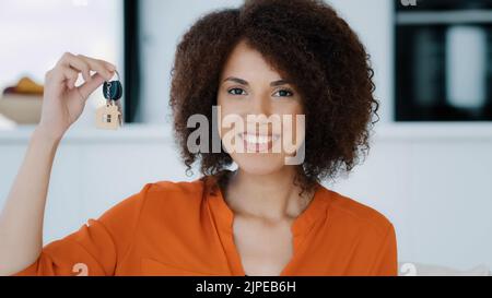Portrait African exited Frau schaut in die Kamera zeigt Bunch Keys feiert Erfolg beim Kauf eines neuen Hauses. Die schamhafte Dame bekommt eine Immobilienmöglichkeit Stockfoto