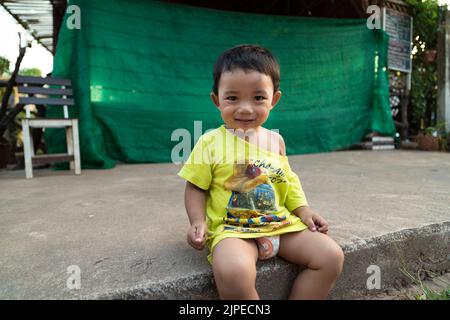 KOH LANTA, KRABI, THAILAND. 30. März 2016. Bunte Straßen der Stadt Koh Lanta. Leben in der traditionellen thailändischen Landschaft. Porträt von niedlichen Thai junge. Stockfoto