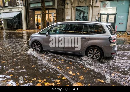 Das Auto fährt durch die überflutete Store Street im Zentrum Londons nach terrentiellem Regenguss, England, Großbritannien, Klimawandel. Stockfoto