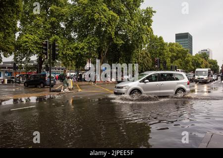 Auto fährt durch überflutete Euston Road in Zentral-London nach Regensturm, England, Großbritannien, British Weather. Stockfoto