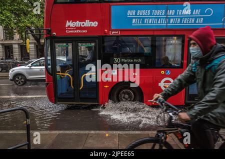London Bus fährt durch überflutete Euston Road in London nach Sturzfluten, England, Großbritannien, Wetter. Stockfoto
