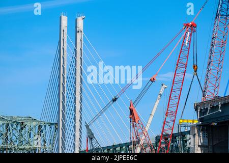 Eine alte Brücke wird gerade abgerissen, neben einer neuen Brücke mit Kabelgestasten. Stockfoto