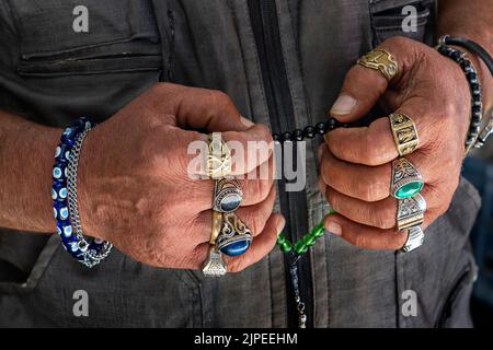 Hände tragen Ringe und halten Sorgenperlen, Türkei Stockfoto