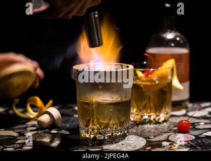 Zünden Sie Holzschnitzeln in einem der einen altmodischen Cocktail. Stockfoto