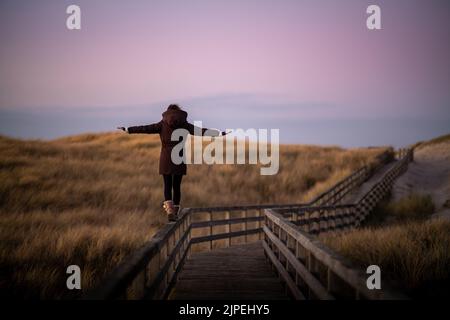Junge Frau balanciert auf Sylt, Deutschland. Stockfoto
