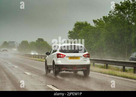 Swindon, England - Mai 2022: Verkehr auf der Autobahn M4 bei schlechtem Wetter mit PKWs und schlechten Fahrbedingungen und Sichtverhältnissen Stockfoto