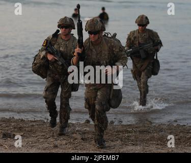 Soldaten der 2. Brigade Combat Team Strike 101. Airborne Division (Air Assault), 18. Airborne Corps, bewegen sich aus dem Wasser und auf den Strand während einer FORSCOM Best Squad Competition Wasser Insertion Veranstaltung auf Fort Hood, Texas, 16. August 2022. Jedes dieser Veranstaltungen soll die körperliche und geistige Stärke sowie die Letalität der einzelnen Kader testen, um zu sehen, welche Kader FORSCOM beim Wettbewerb „Beste Kader der Armee“ vertreten wird, der in Ft stattfinden wird. Bragg. Stockfoto