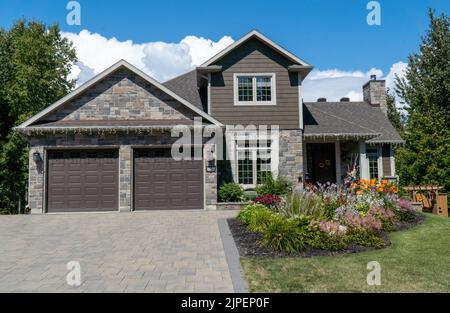 Schönes Einfamilienhaus mit schön getrimmtem und landschaftlich gestaltetem Vorgarten, Rasen in einer Wohngegend. New Liskeard, Ontario Stockfoto