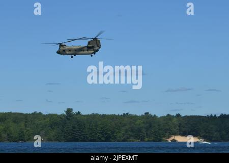 Ein CH-47 Chinook, 111. General Support Aviation Bataillon, Florida Army National Guard, fliegt während des Northern Strike 22-2, in Camp Greyling, Michigan, 11. August 2022, über den Lake Margrethe. Einheiten, die Northern Strike besuchen, nutzen Lake Margrethe regelmäßig für die Durchführung von Küstenoperationen (USA Air National Guard Foto von Staff Sgt. Tristan D. Viglianco) Stockfoto