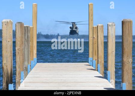 Ein CH-47 Chinook, 111. General Support Aviation Bataillon, Florida Army National Guard, fliegt während des Northern Strike 22-2, in Camp Greyling, Michigan, 11. August 2022, über den Lake Margrethe. Einheiten, die Northern Strike besuchen, nutzen Lake Margrethe regelmäßig für die Durchführung von Küstenoperationen (USA Air National Guard Foto von Staff Sgt. Tristan D. Viglianco) Stockfoto