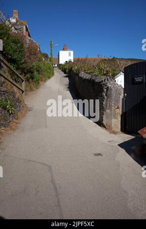 Schmale Straße, die zu Häusern in Port Isaac führt. Cornwall, England Stockfoto