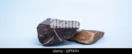 Banner mit schwarzen und braunen Natursteinen Podium auf hellblauem Hintergrund, Plattform für Produktdisplay. Rohling für Mockup-Design. Speicherplatz kopieren. Stockfoto