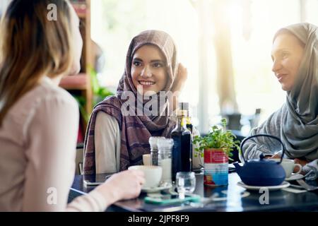 Mit den Mädchen aufzuholen ist immer eine gute Idee. Eine Gruppe von Frauen plaudert bei einem Kaffee in einem Café. Stockfoto