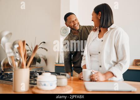 Lächelnd, lachend und liebevoll, ein Paar in der Küche mit Kaffee. Glückliche, liebevolle und entspannende, romantische neue Hausbesitzer ihr Haus. Romantik, Ehe Stockfoto