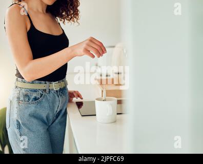 Frau hält Kräutertee-Beutel über einer Tasse kochendem Wasser und macht Chai in der Küche, der eine Pause macht. Barista-Frau, die im Café oder Kaffee arbeitet Stockfoto