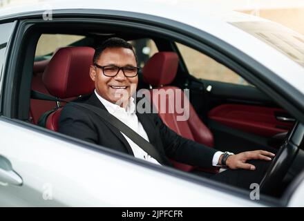 Heute wird ein Guten Tag. Hochwinkelporträt eines gutaussehenden, reifen Geschäftsmannes, der sein Auto auf seinem morgendlichen Weg zur Arbeit fährt. Stockfoto