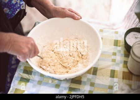 Großmutter mischte Teig für Pfannkuchen Stockfoto