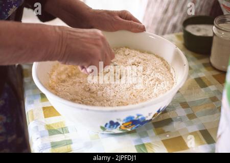 Großmutter mischte Teig für Pfannkuchen Stockfoto