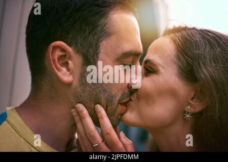 Wer braucht Worte, wenn es Küsse gibt. Ein glückliches junges Paar, das einen liebevollen Moment im Freien teilt. Stockfoto