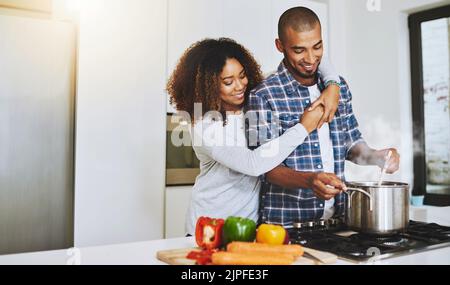 Ich habe den besten Koch und Ehemann. Ein junges Paar kocht zusammen zu Hause. Stockfoto